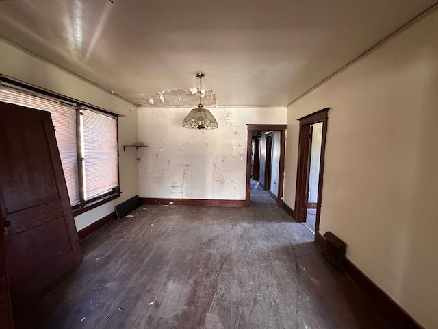 spare room with baseboards and dark wood finished floors