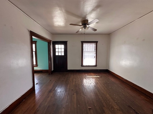 unfurnished room with wood-type flooring, a ceiling fan, and baseboards