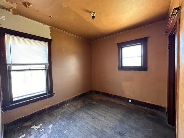 unfurnished room with baseboards and dark wood-style flooring