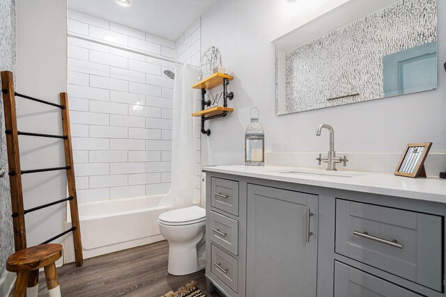 full bath with vanity, shower / tub combo, wood finished floors, and toilet