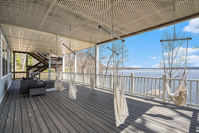 wooden terrace featuring stairway and a water view