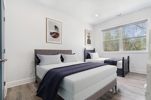 bedroom featuring baseboards, recessed lighting, wood finished floors, and visible vents