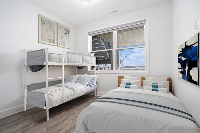 bedroom featuring baseboards, visible vents, and wood finished floors