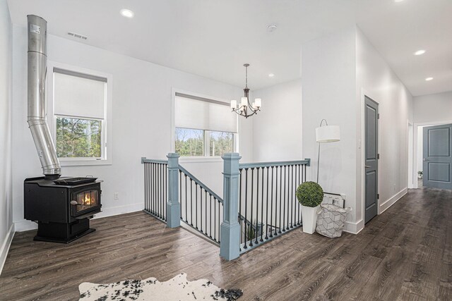 hallway with visible vents, wood finished floors, and a wealth of natural light