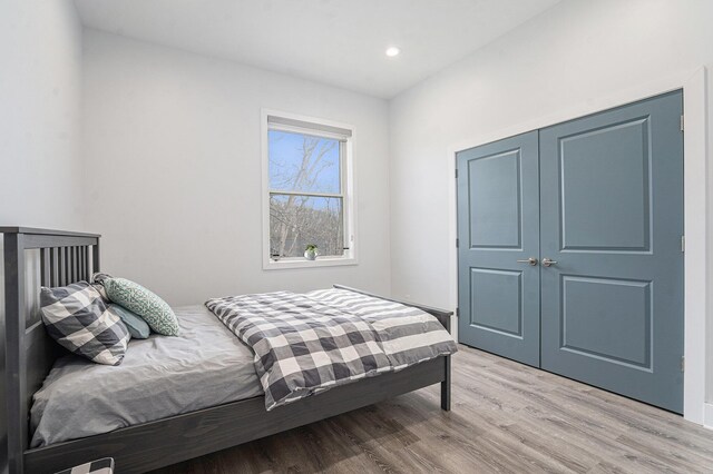 bedroom featuring recessed lighting, light wood-style flooring, and a closet