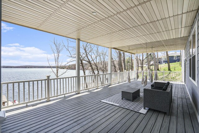wooden deck with an outdoor living space and a water view