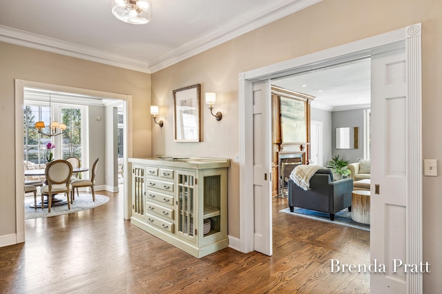 hall with crown molding, baseboards, and wood finished floors