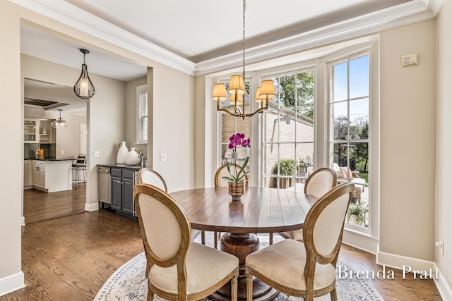 dining space with an inviting chandelier, baseboards, crown molding, and dark wood-type flooring