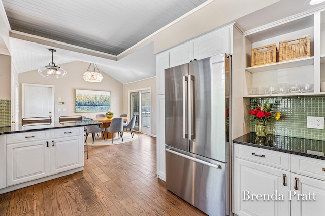 kitchen with freestanding refrigerator, lofted ceiling, wood finished floors, and white cabinetry