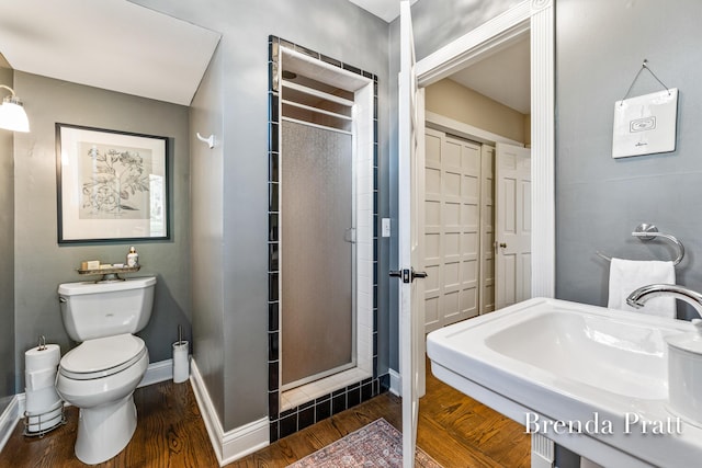 full bath with a shower stall, wood finished floors, a sink, baseboards, and toilet