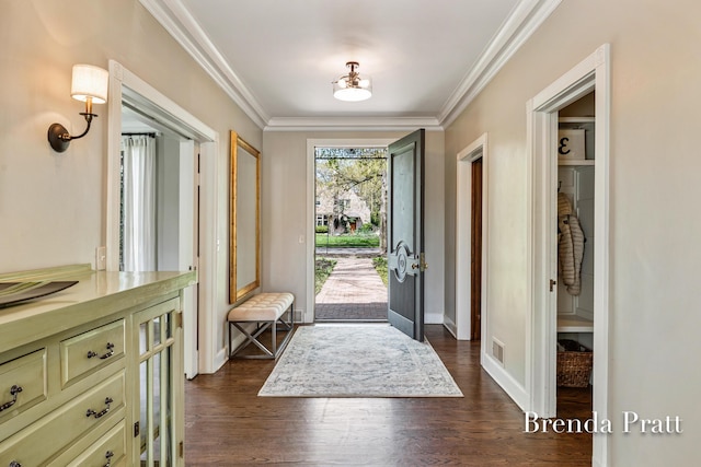 foyer entrance with baseboards, ornamental molding, dark wood finished floors, and visible vents
