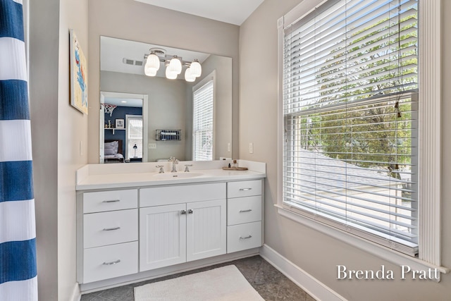 bathroom with visible vents, baseboards, vanity, tile patterned floors, and ensuite bathroom