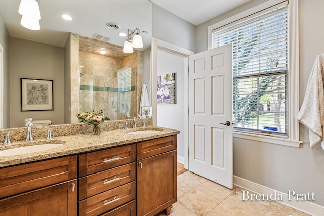 full bathroom with a sink, baseboards, tile patterned flooring, and a stall shower