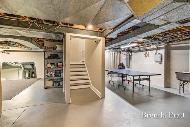 unfinished basement with electric panel, stairs, and visible vents