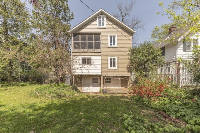 rear view of property with a lawn and fence