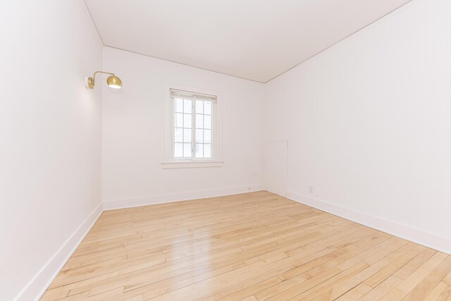 empty room with baseboards and light wood finished floors