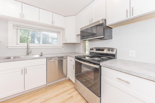 kitchen featuring a sink, light countertops, stainless steel appliances, and light wood-type flooring