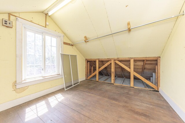 additional living space featuring baseboards, wood finished floors, and lofted ceiling