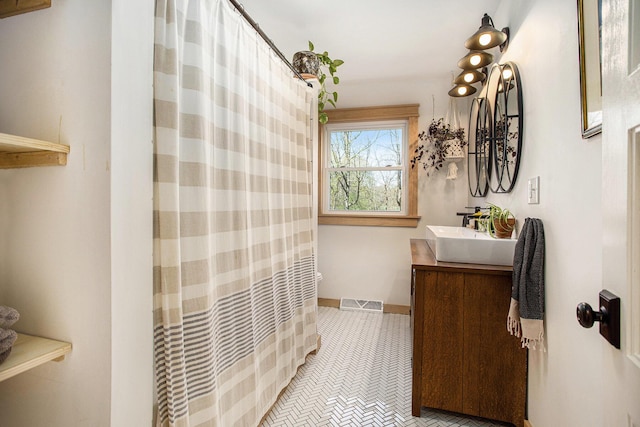 full bath featuring baseboards, visible vents, a shower with shower curtain, and vanity