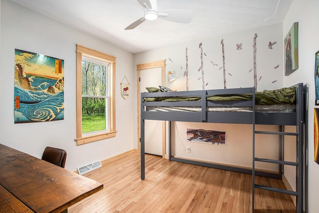 bedroom featuring baseboards, light wood finished floors, and visible vents
