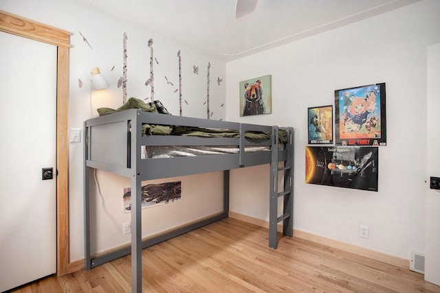 bedroom with baseboards, a ceiling fan, and wood finished floors