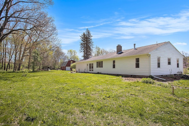 back of property with a lawn and a chimney
