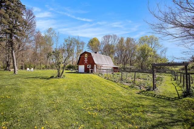 view of yard featuring a barn, fence, and an outbuilding