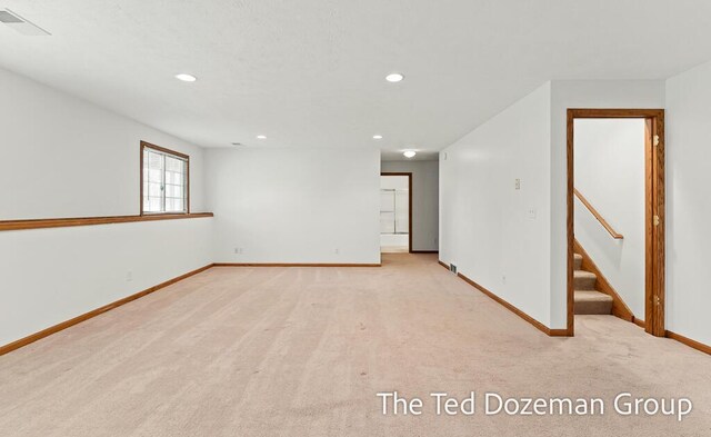 spare room featuring recessed lighting, baseboards, visible vents, and light carpet