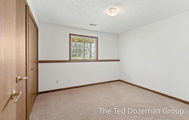 unfurnished bedroom with baseboards, visible vents, light carpet, and a closet