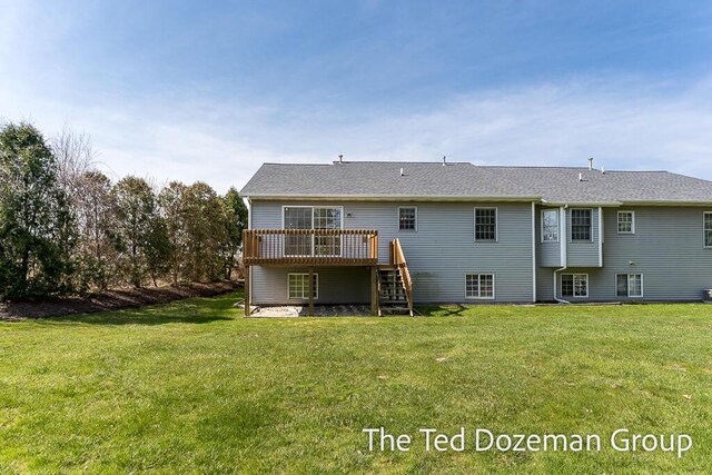 back of house featuring a lawn, a wooden deck, and stairway