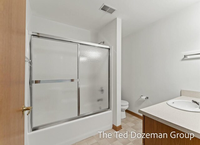full bath with vanity, toilet, enclosed tub / shower combo, baseboards, and visible vents