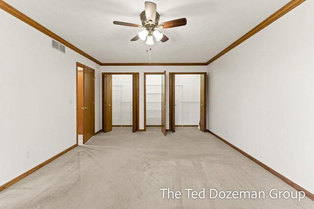 unfurnished bedroom featuring visible vents, baseboards, crown molding, and light carpet