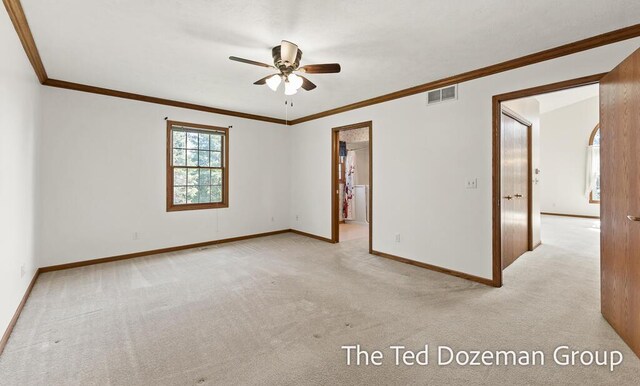 spare room with baseboards, ceiling fan, light colored carpet, and visible vents