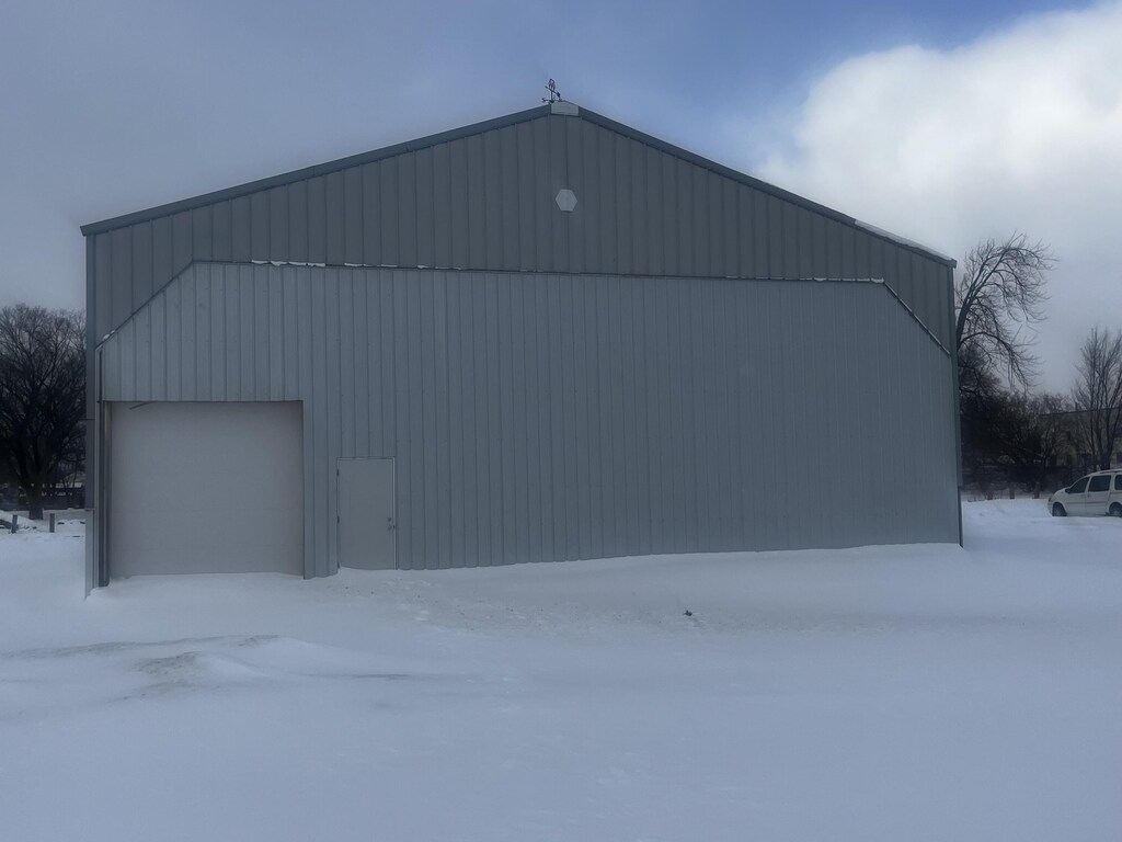 snow covered structure featuring an outdoor structure
