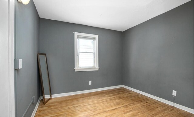 spare room featuring baseboards and light wood-style flooring