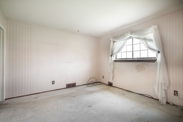 carpeted empty room featuring ornamental molding and visible vents