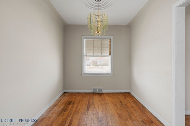 18626 Prevost St, Detroit, MI 48235 - spare room featuring baseboards, a notable chandelier, hardwood / wood-style flooring, and visible vents