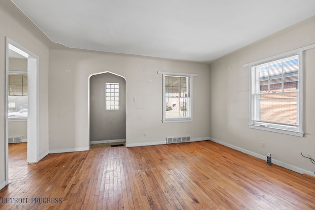 18626 Prevost St, Detroit, MI 48235 - empty room featuring arched walkways, baseboards, visible vents, and light wood-style floors