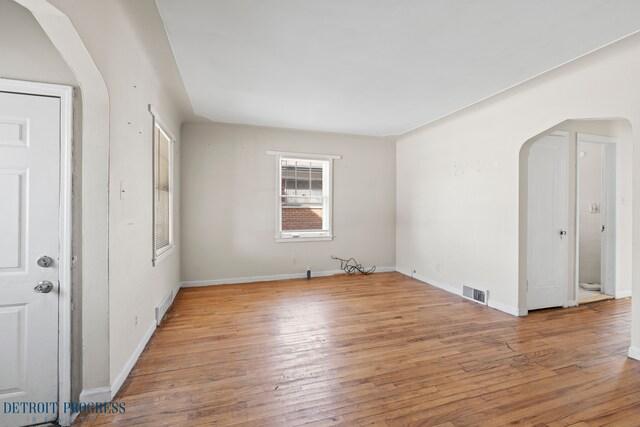 18626 Prevost St, Detroit, MI 48235 - unfurnished room featuring arched walkways, baseboards, visible vents, and hardwood / wood-style floors