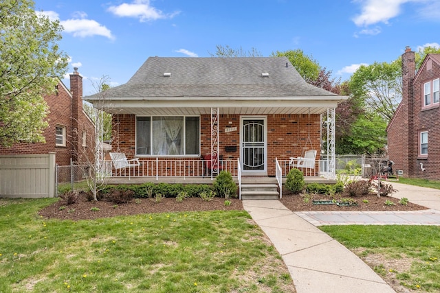 bungalow with fence, a porch, and a front yard