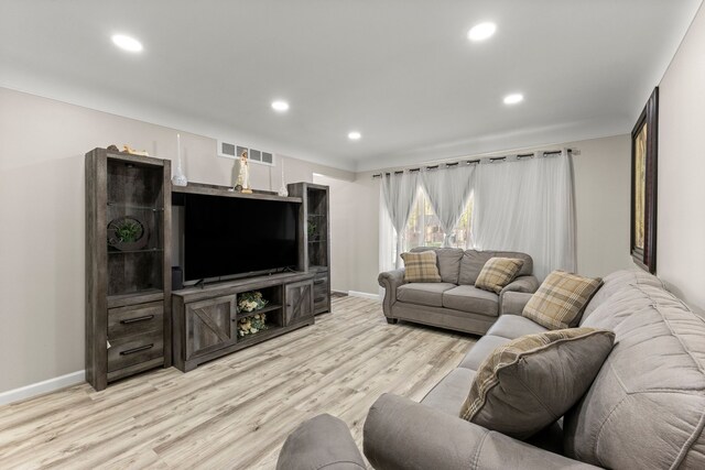 living area featuring baseboards, visible vents, and light wood-style floors