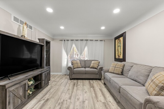 living area with baseboards, recessed lighting, and light wood-style flooring