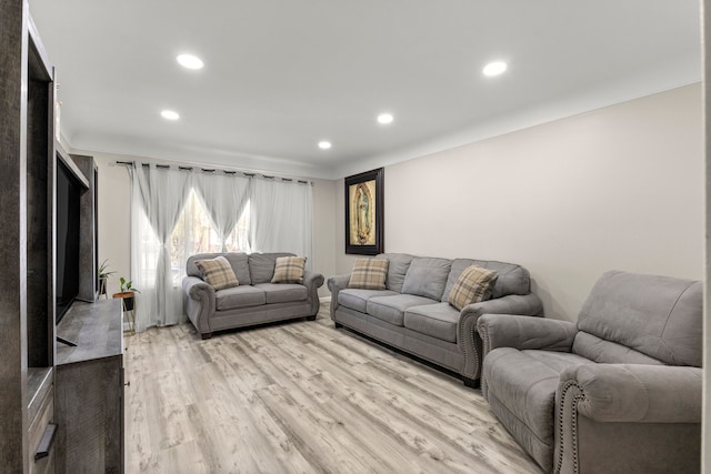 living area with recessed lighting, ornamental molding, and light wood-style floors