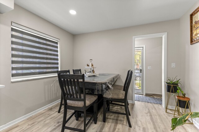 dining room with recessed lighting, baseboards, and light wood finished floors