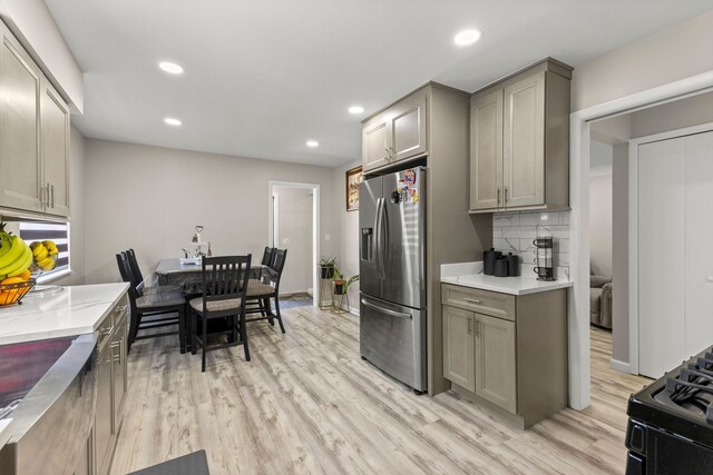 kitchen featuring stainless steel refrigerator with ice dispenser, recessed lighting, gray cabinets, and light wood finished floors