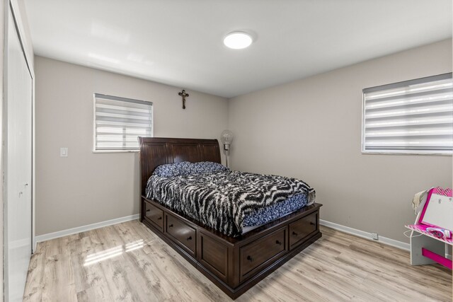 bedroom featuring light wood-style floors and baseboards