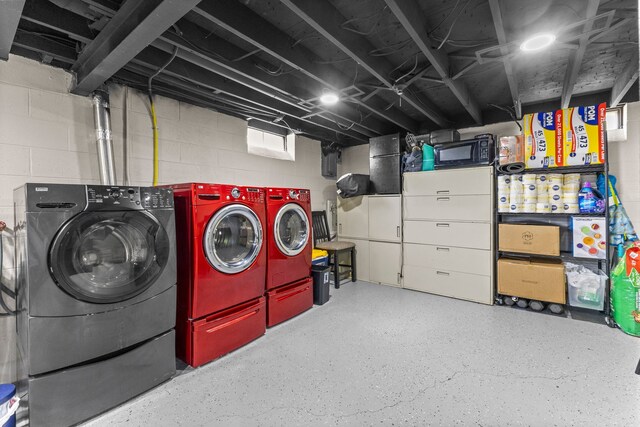 unfinished below grade area with washer and clothes dryer and concrete block wall