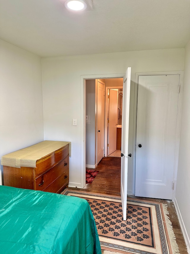 bedroom with baseboards and wood finished floors