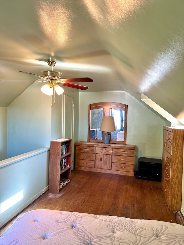 bedroom with a textured ceiling, vaulted ceiling, dark wood-style floors, and ceiling fan