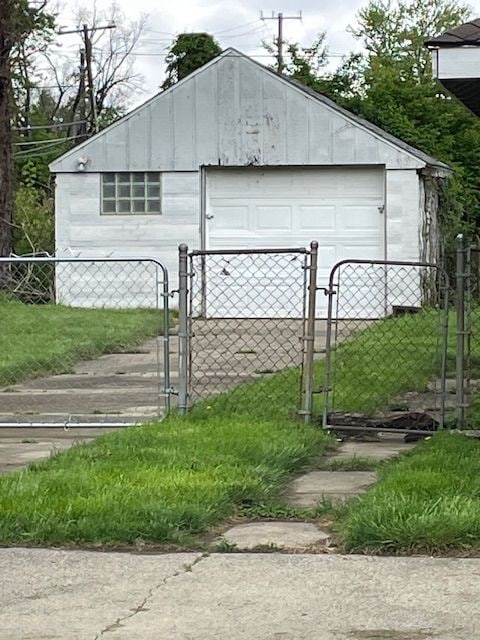 view of outbuilding with a gate, fence, and an outdoor structure